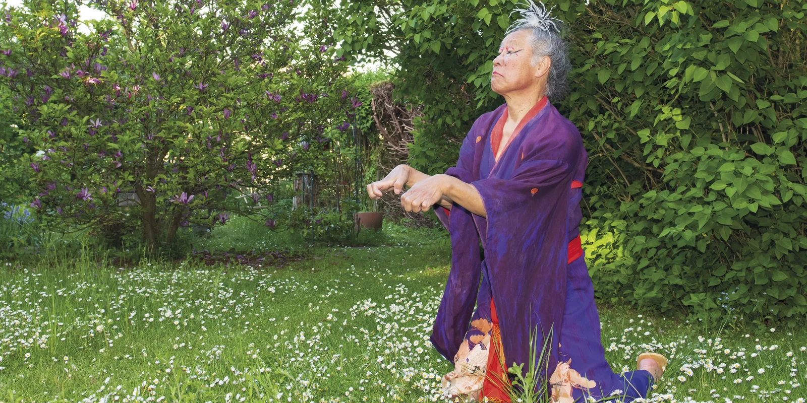 Tadashi Endo tanzt kniend Butho in einem Garten