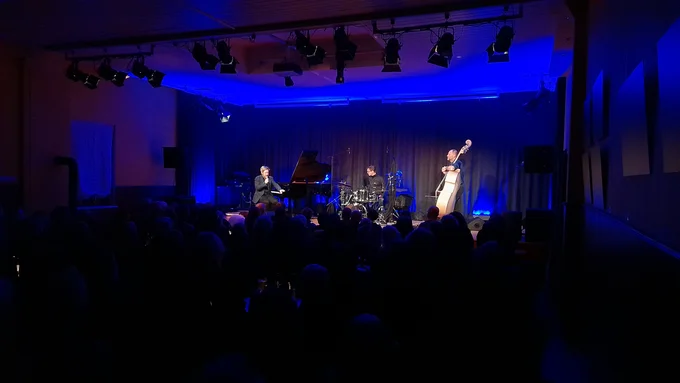 Das Helge Lien Trio, mit Flügel, Schlagzeug und Kontrabass spielt auf der Bühne des Kulturzentrum "Kultur im Esel" im blauen Licht.