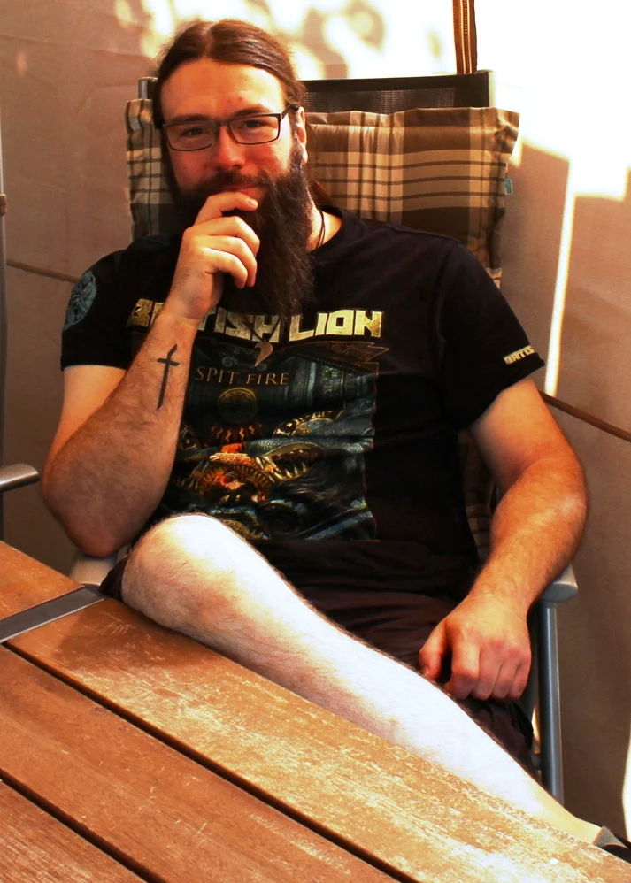 Niklas Kahl sitzt auf einem Gartenstuhl. 