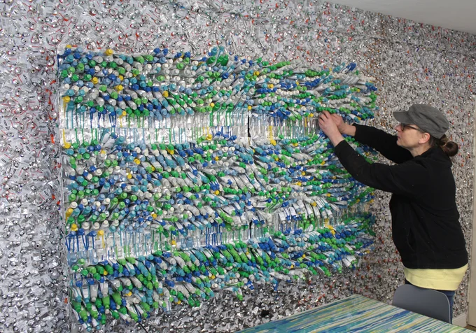 Die Künstlerin Kerstin Schulz arbeitet an dem Schwarmkunstwerk eines Wandbildes, bestehend aus etwa 12.000 ausgedrückten Farbtuben