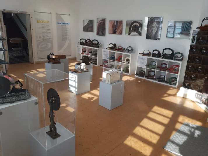 Ausstellungsraum in Ebergötzen – Brotschneidemaschinen im Hintergrund, vorne andere Ausstellungsobjekte