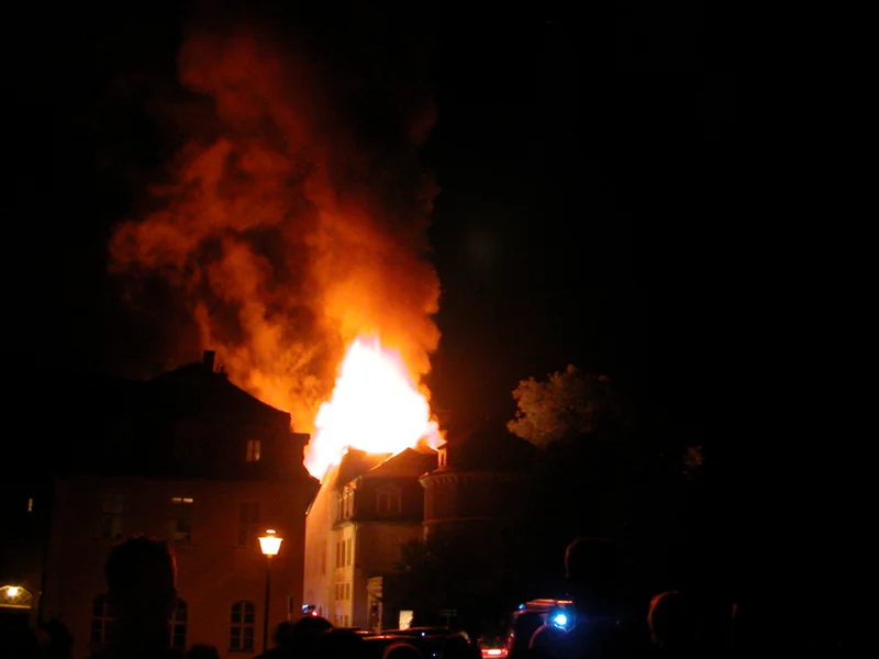 Foto der brennenden Anna Amalia Bibliothek in Weimar - Flammen lodern hoch über dem Dach des Gebäudes.