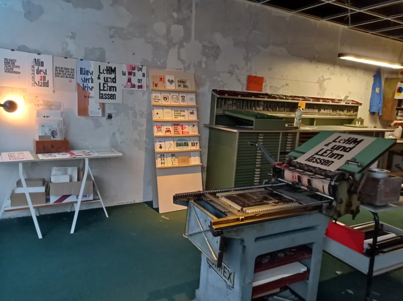 Druckerbande - Blick in die Werkstatt: Mittig eine Druckerpresse