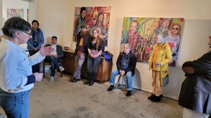 Kuratorin erklärt die Ausstellung den Besuchern im Atelier