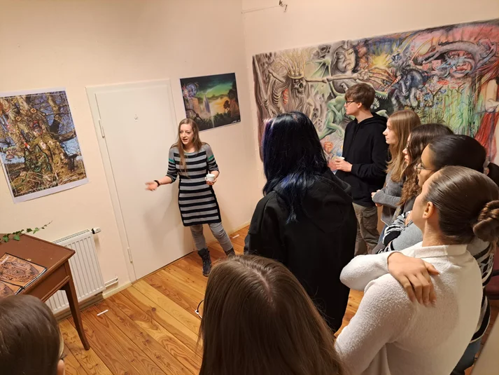 Künstlerin erklärt jungen Erwachsenen ihre Bilder im Atelier