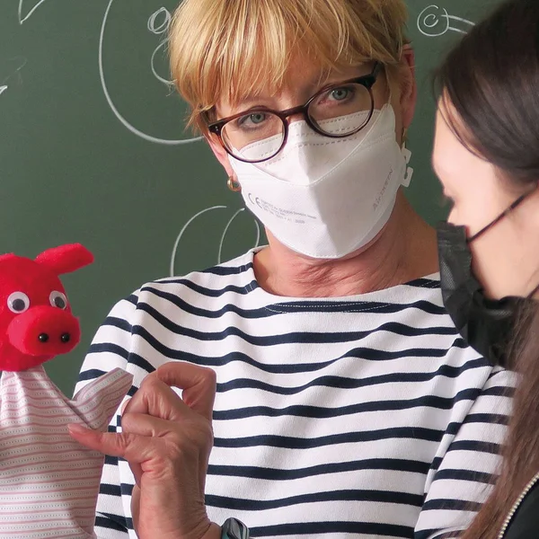 Eine Lehrerin zeigt einer Schülerin eine Stabfigur