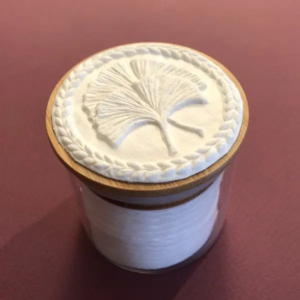 Papiermedallion mit Gingkoblatt auf einer Glasdose