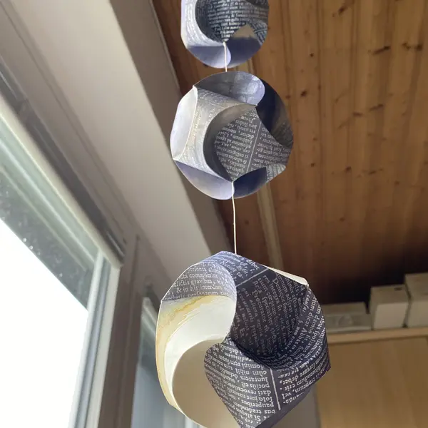 drei Papierkugeln die als Windspiel von der Decke hängen