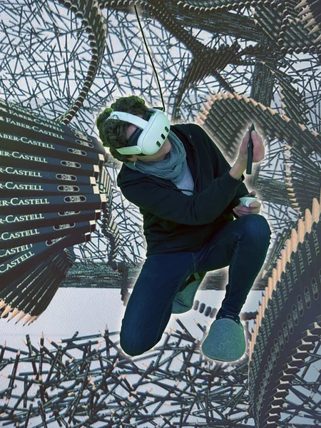 ein Mensch kniet mit einer VR Brille, um ihn herum viele virtuelle Bleistifte