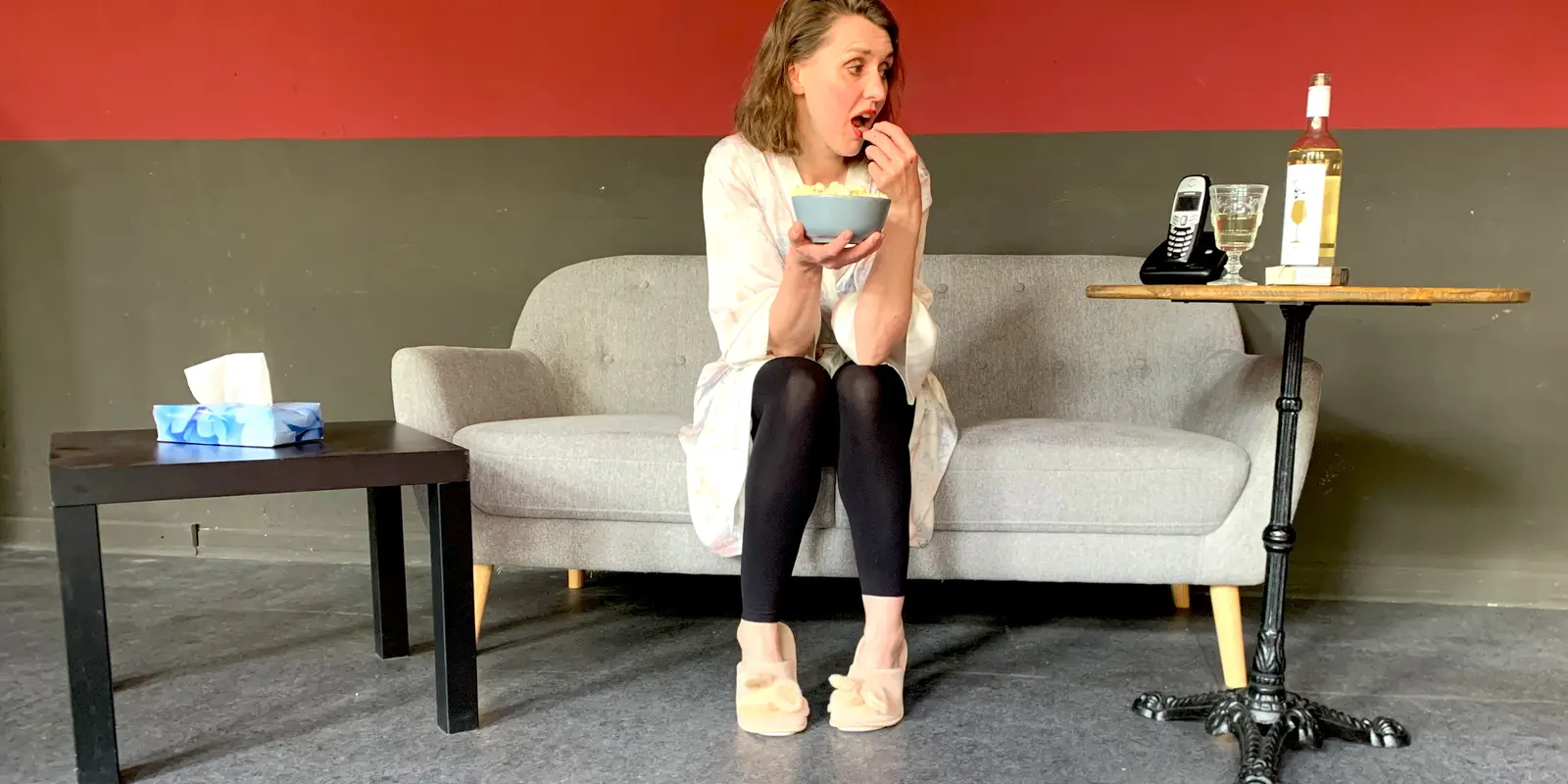 Schauspielerin Susanne Rösch sitzt auf einem Sofa und wartet.