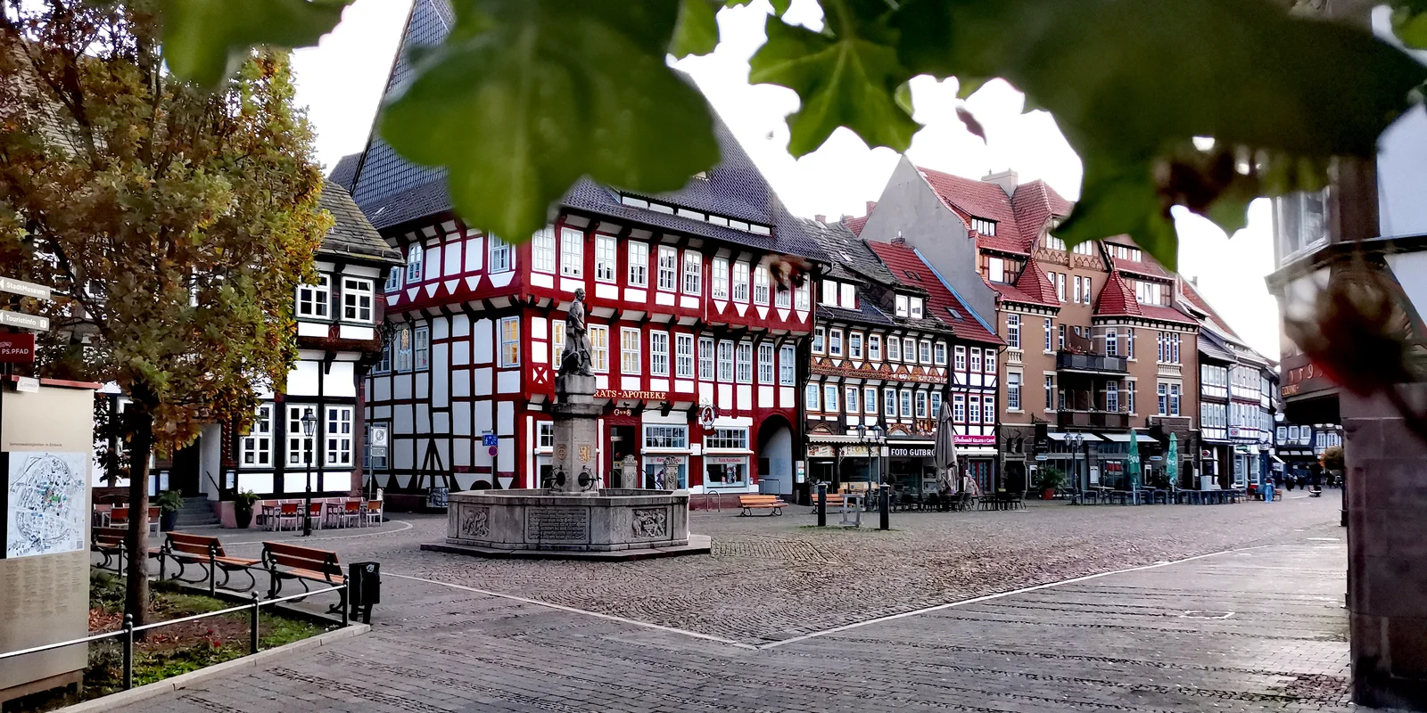 Blick auf den Marktplatz von EInbeck im Hintergrund die Ratsapotheke, davor ein Brunnen