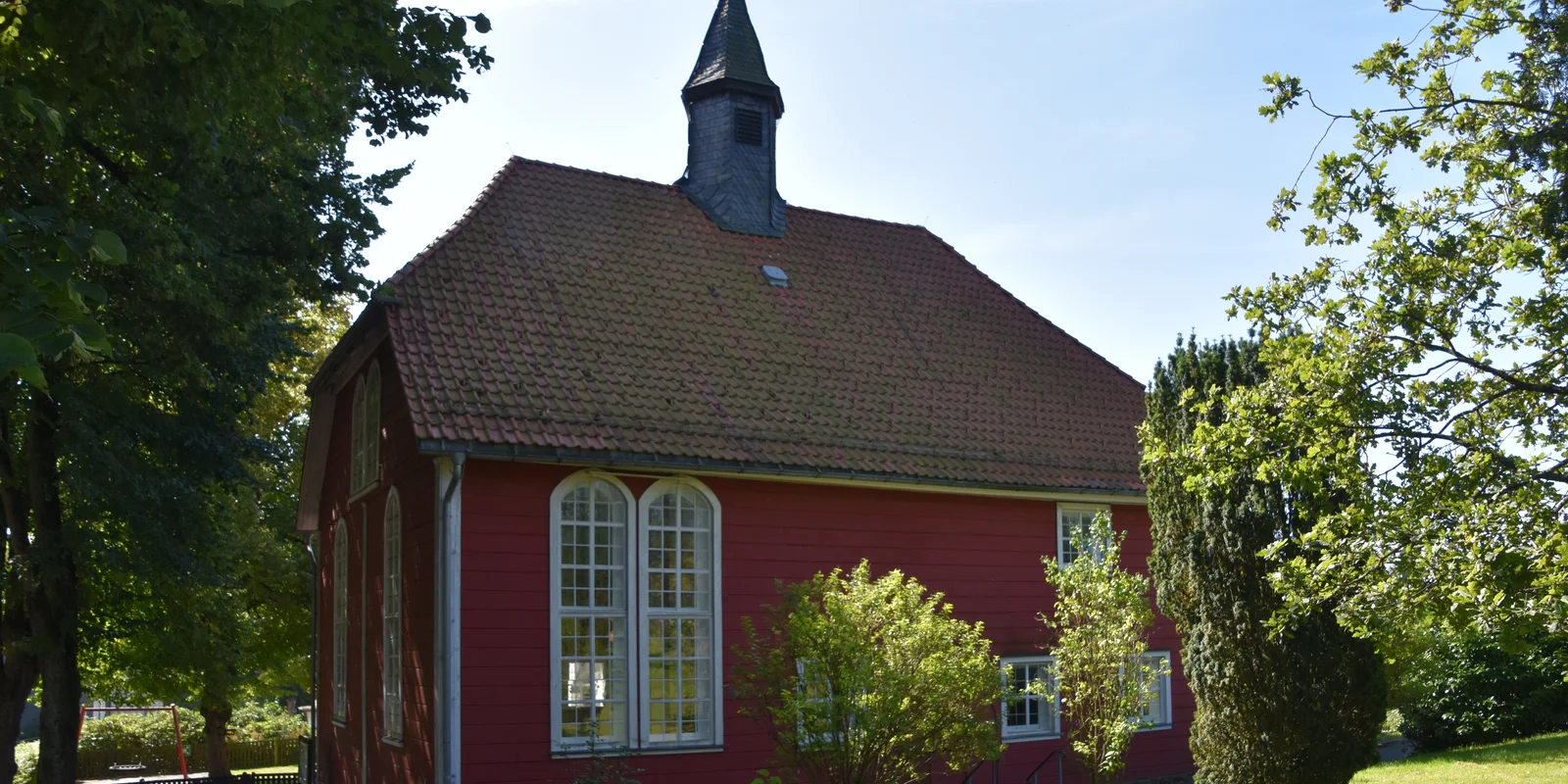 Dorfkirche Buntenbock: Rote Holzfassade mit weißen Fenstern und dunkel gedecktem Dach