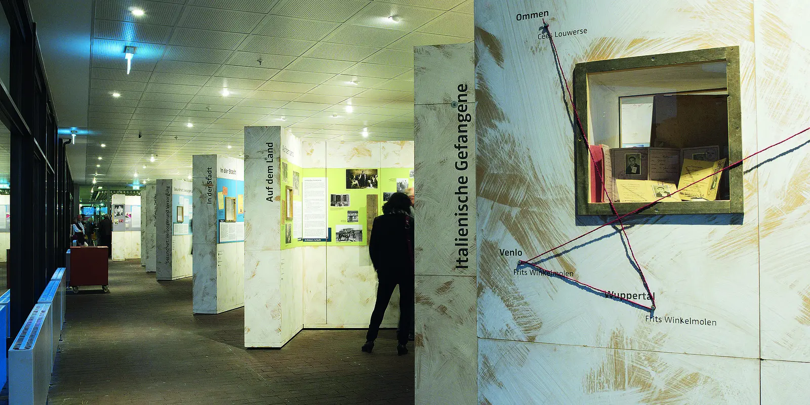 Eine Person betrachtet die Ausstellungstafeln zur Zwangsarbeit auf dem Land.