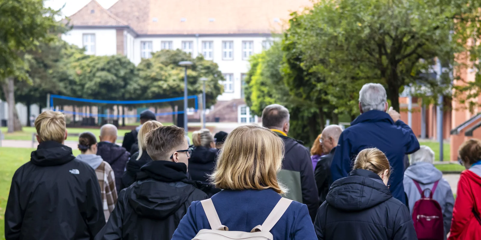 Besuchende der Gedenkstätte bei einem Rundgang im Innenhof des ehemaligen KZ-Geländes.