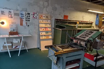 Druckerbande - Blick in die Werkstatt: Mittig eine Druckerpresse
