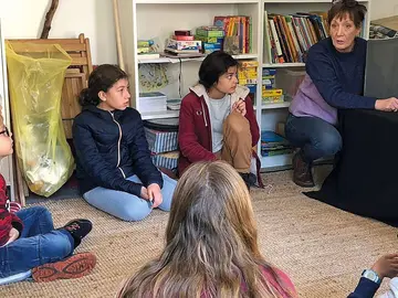 Kinder sitzen vor einem Kamishibai