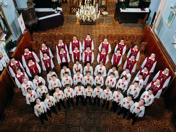 Sänger des Dudaryk Boy's Choir schauen nach oben lächelnd in die Kamera.