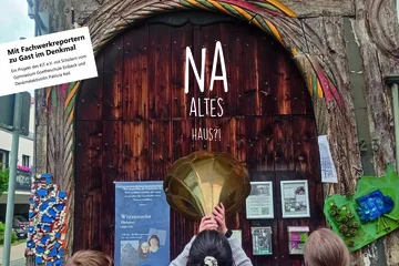 Schriftzug "Na Altes Haus" auf einer Holztür.