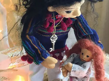 Eine Erwachsene Puppe tröstet eine Kinderpuppe