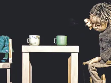 Eine Figur sitzt am Tisch und ist traurig