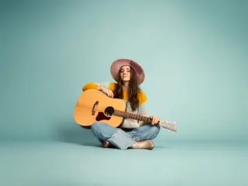Alina Sebastian sitzend mit Gitarre