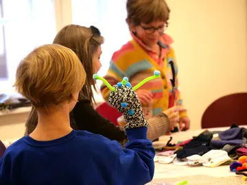 Kinder mit schwarzweißem Sockenmonster mit grünen Fühlern