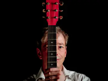 Thorsten Hitschfel mit Gesicht hinter Gitarrenhals