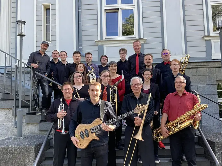 Mitglieder der Big Band stehen auf den Stufen einer Treffe