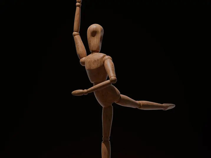 Holzpuppe in Tanzpose, umringt von Zahnrädern
